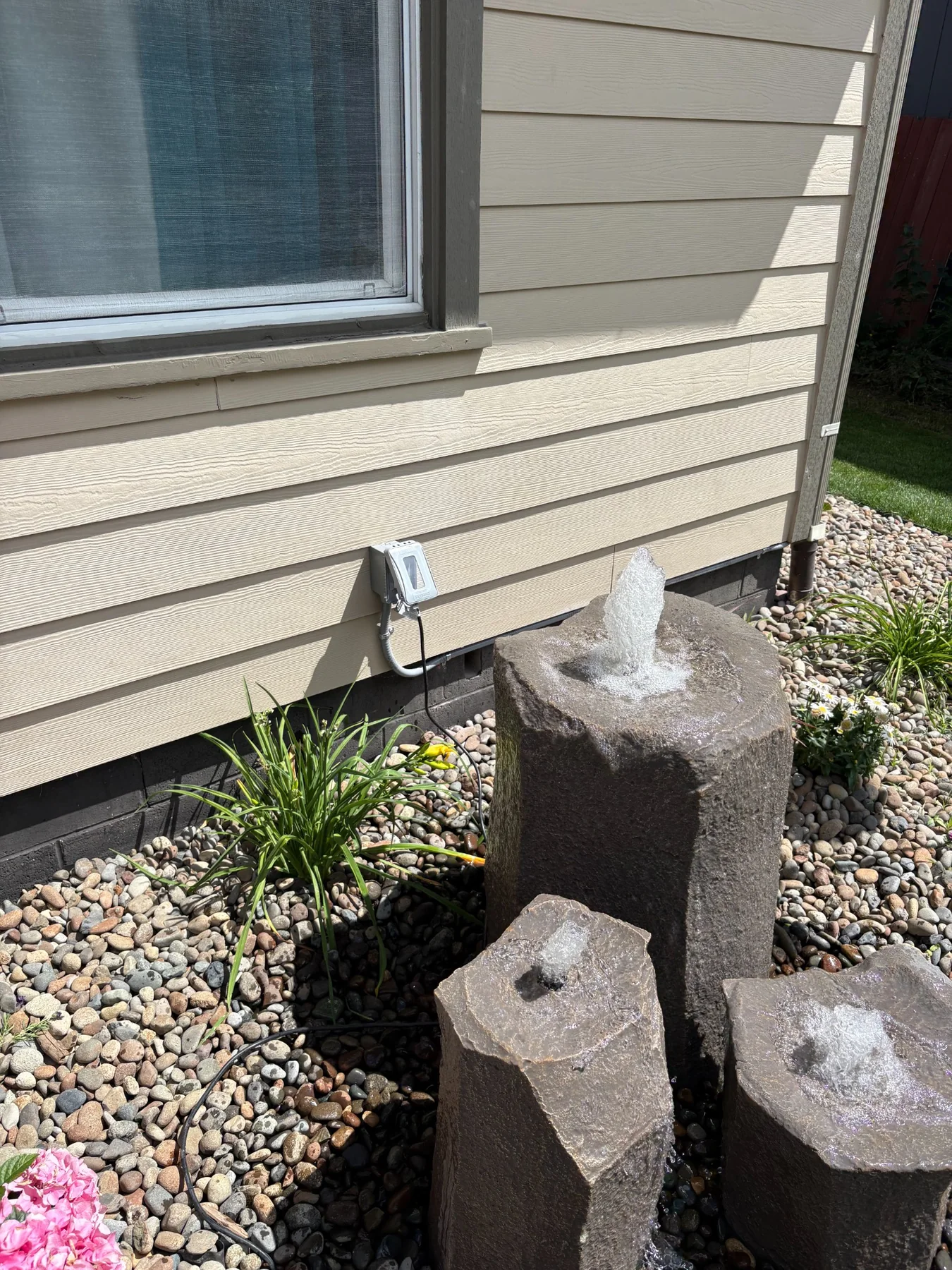 Outdoor electrical power installed beside a rock water feature
